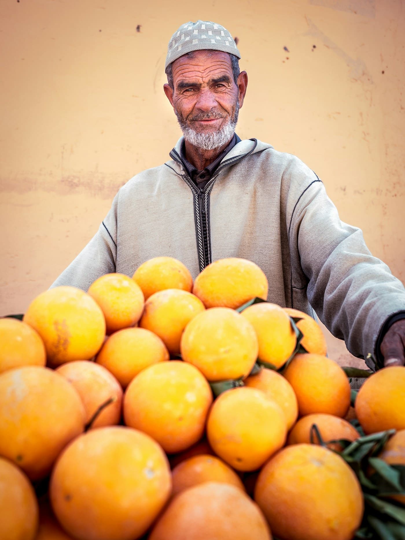 Homme présentant un étal d'oranges, en couverture du catalogue export 2026