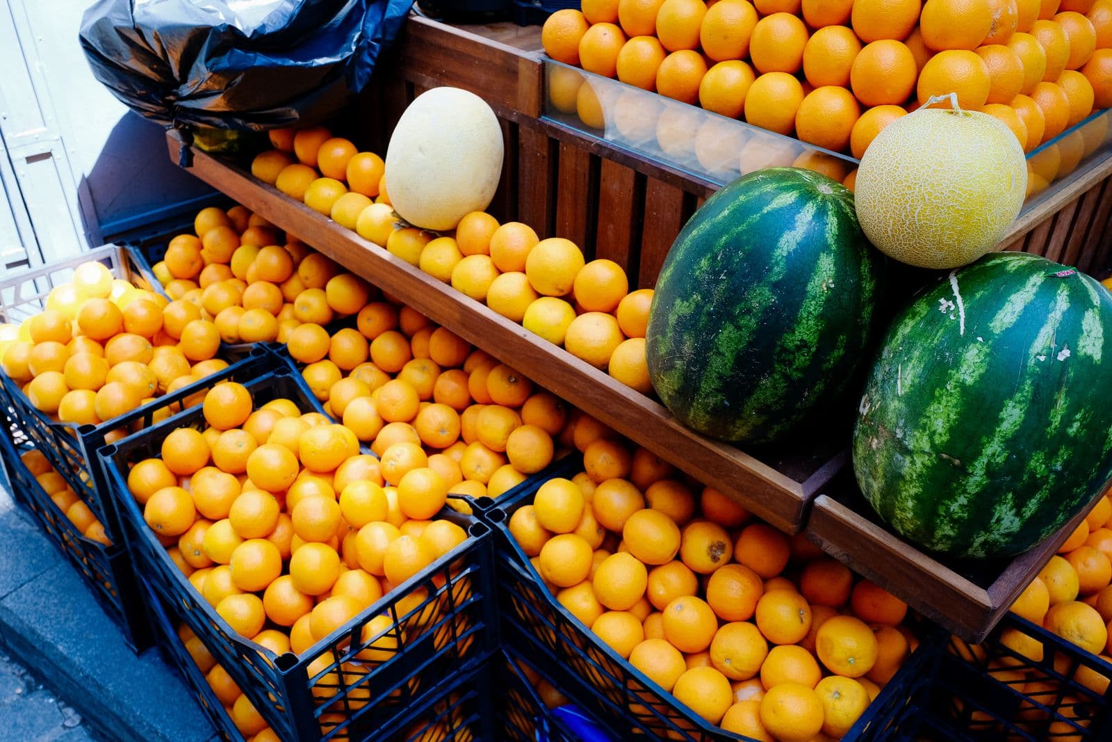 Cagettes d'oranges, de pastèques et de melons du Maroc sur un étal de marché