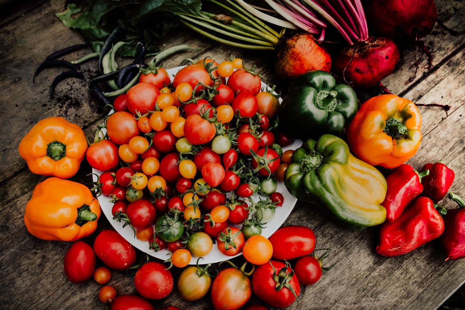 Tomates cerises et poivrons rouges, jaunes et verts sur une table en bois